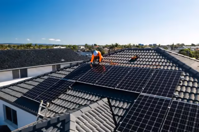 Solar maintenance technician checking rooftop panels in Sydney